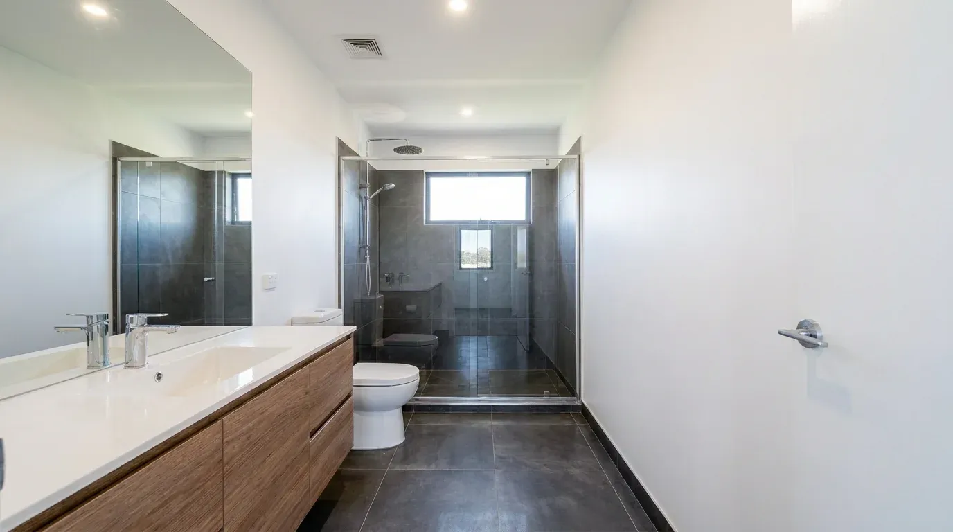 Bathroom with a wooden vanity in a Masías at the Hills model home